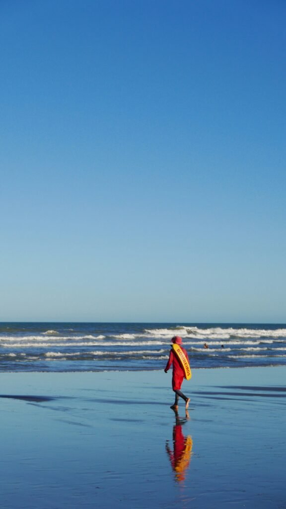 a person walking on a beach with a surfboard